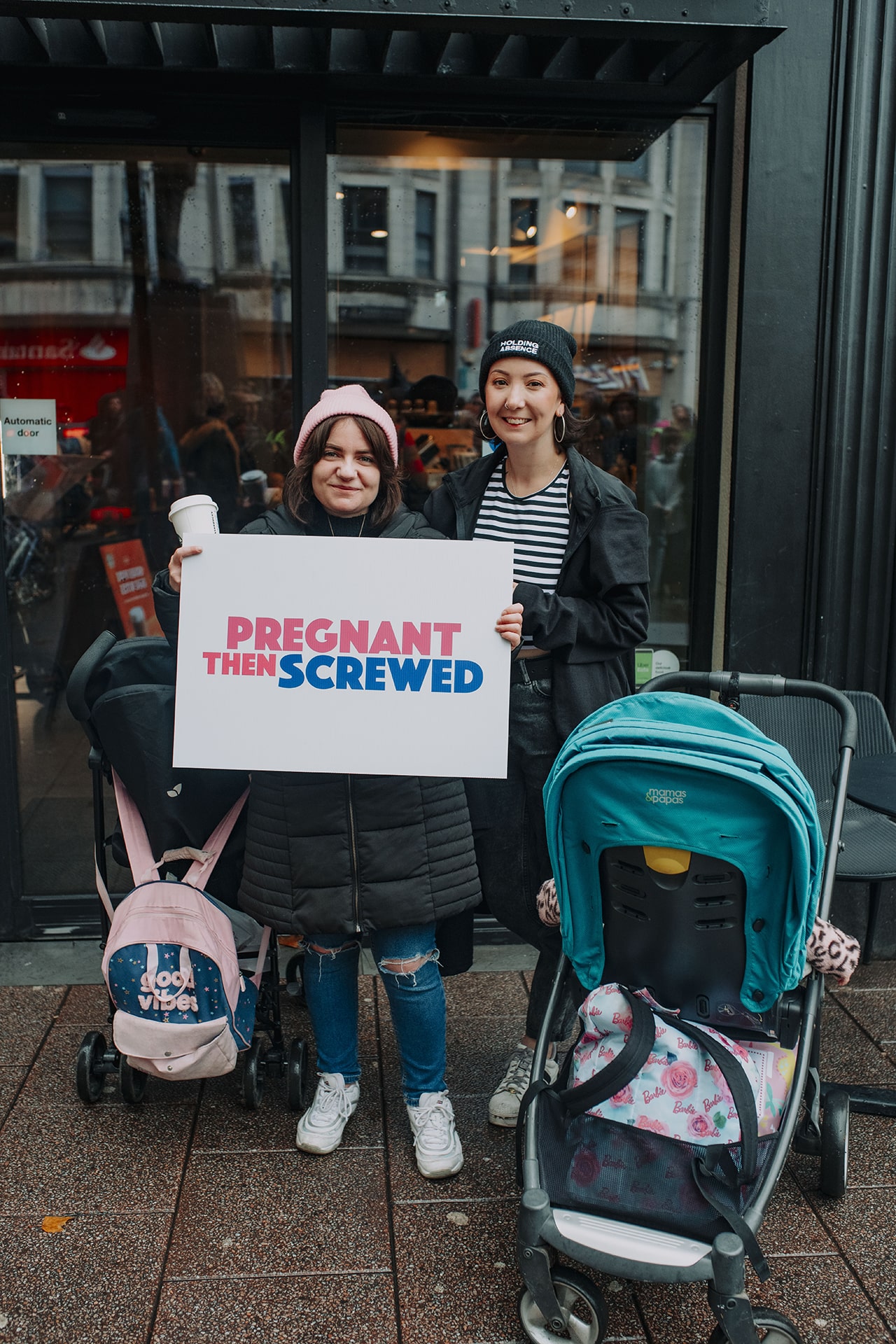 alt text: two women with Pregnant Then Screwed placard