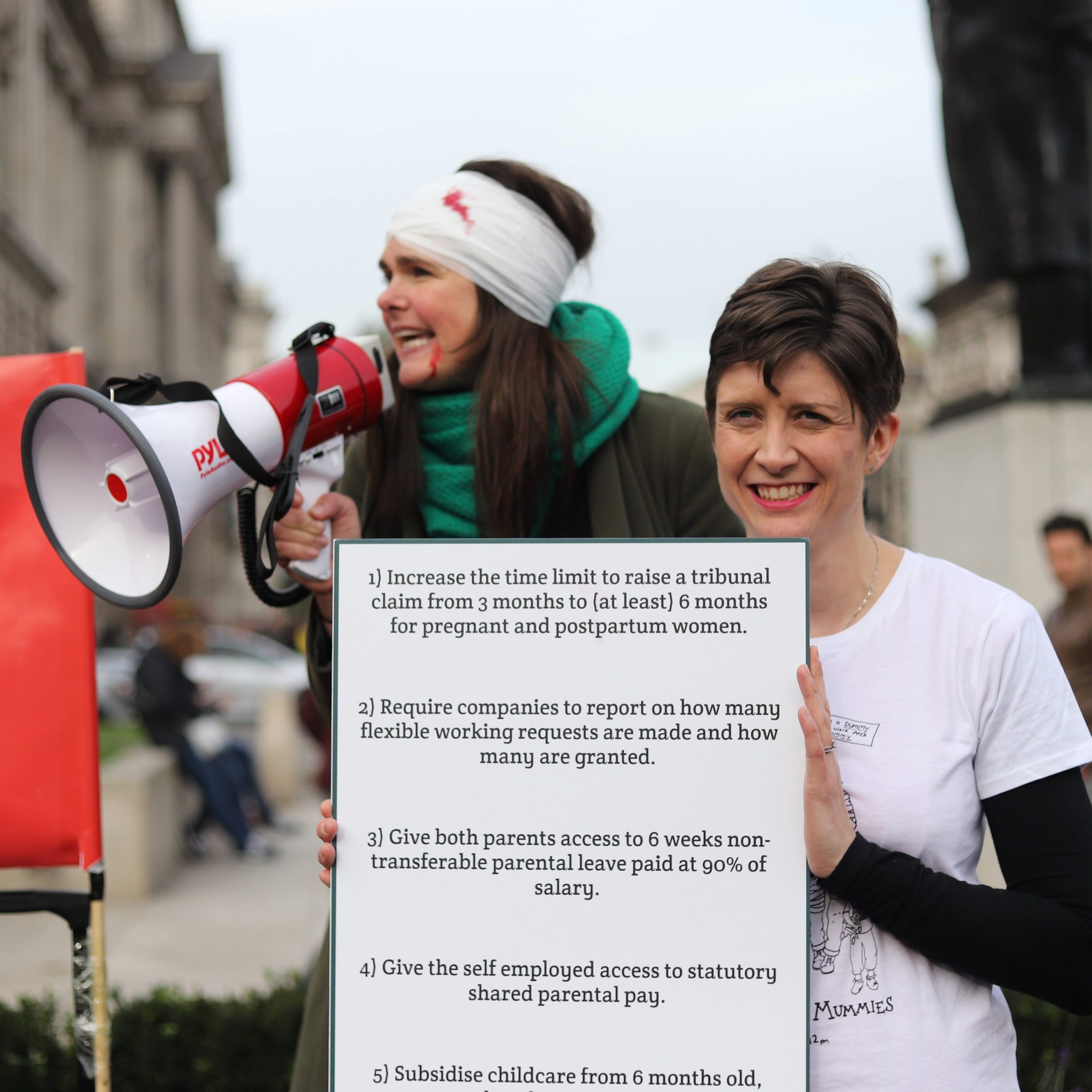 Alt text: Joeli Brearley shouting into megaphone at Pregnant Then Screwed March of The Mummies Protest