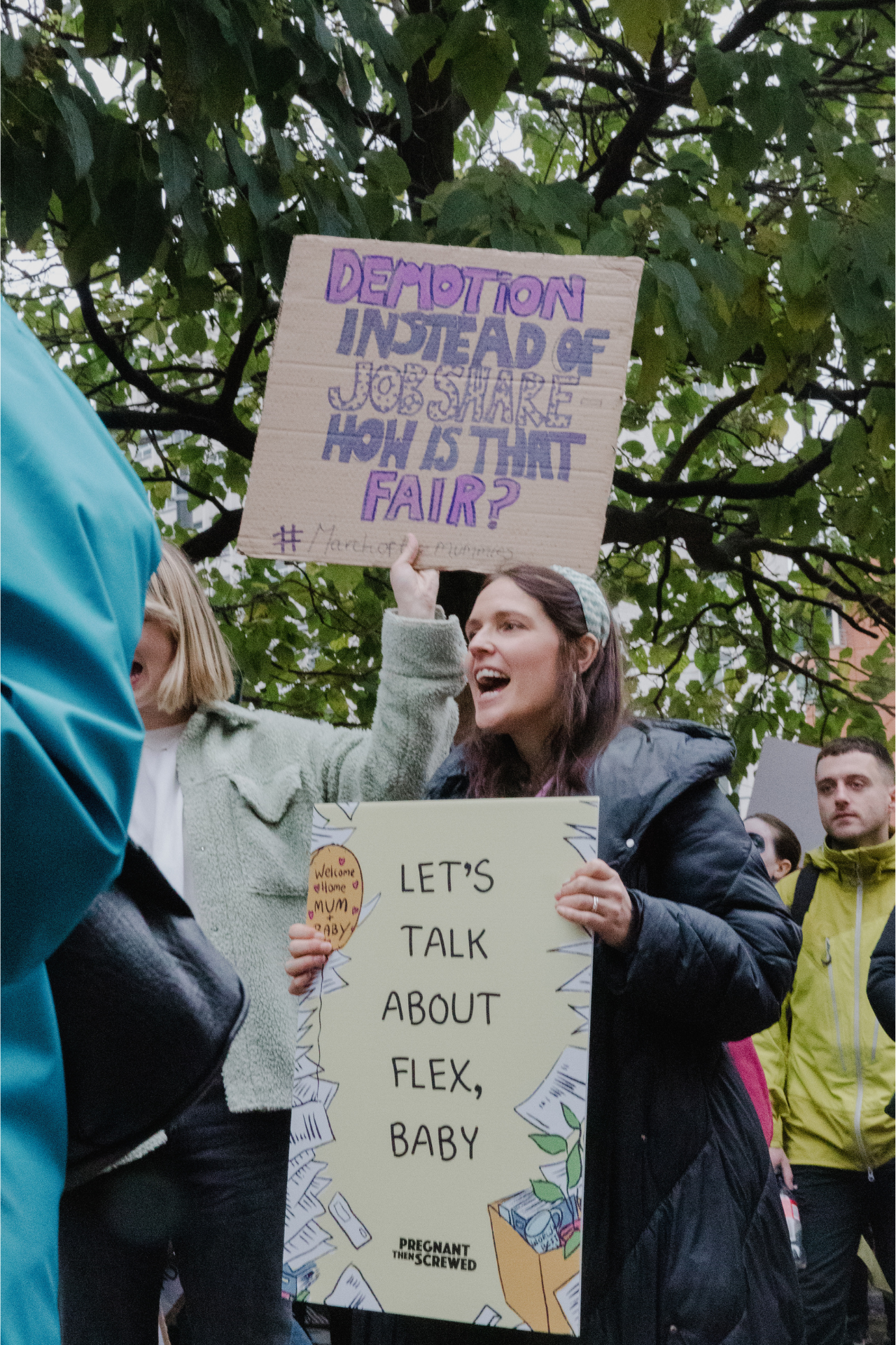 Women hold signs saying 