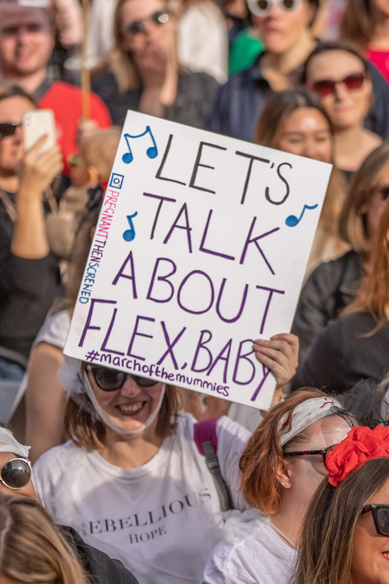 Woman holds sign saying 