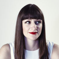 Woman with darks straight hair and a fringe with red lipstick
